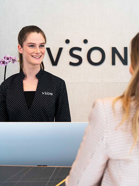Woman in VSON uniform smiles, welcoming someone to the laser eye surgery clinic in Brisbane