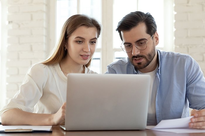 Couple looking at a laptop screen and discussing whether bladeless LASIK is better