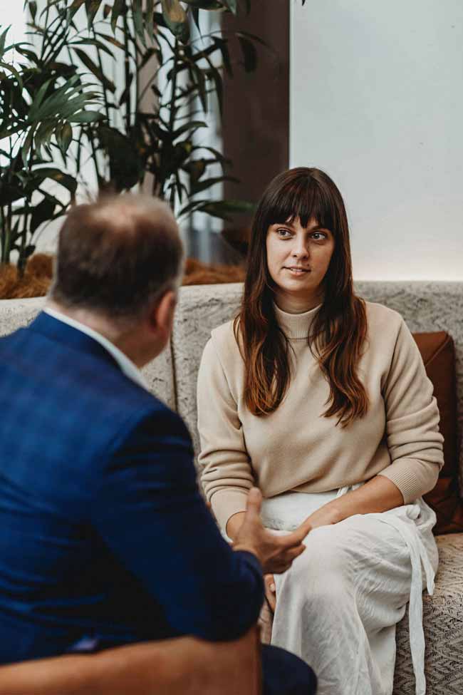 VSON laser eye surgery clinic eye specialist talking to woman sat on sofa listening
