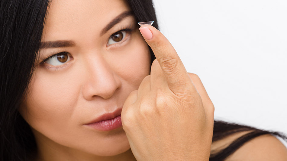 Beautiful woman looking at contact lenses