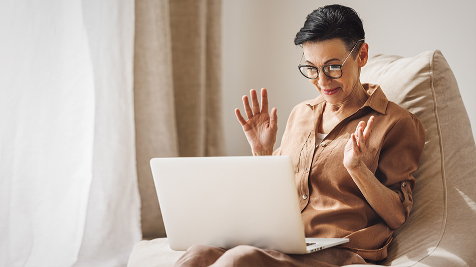 Senior woman with glasses expressing surprise after looking at her laptop