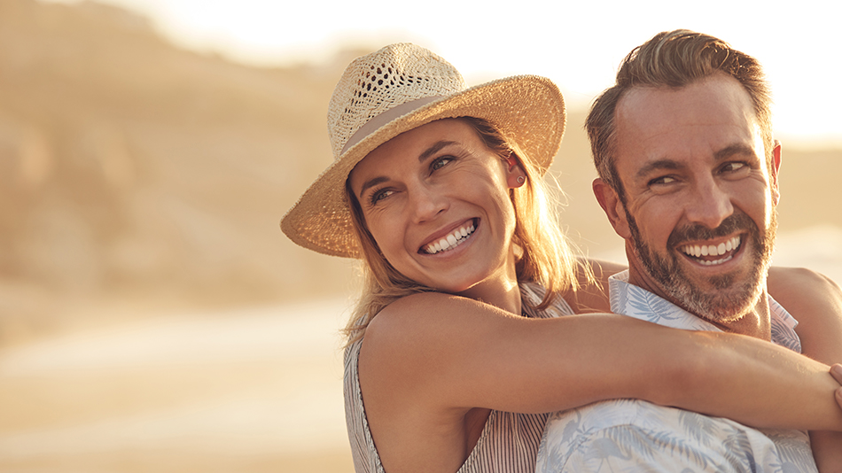 A middle-aged couple enjoying the sunset near the beach.