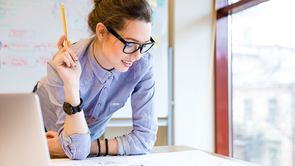 A woman with glasses focuses on her work plan.