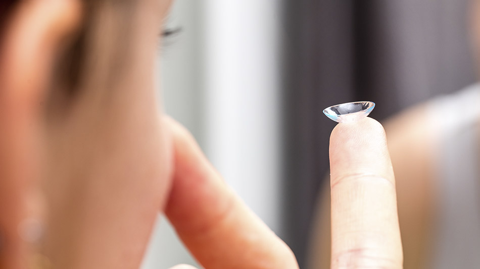 A close-up of a person preparing to insert their contact lenses.